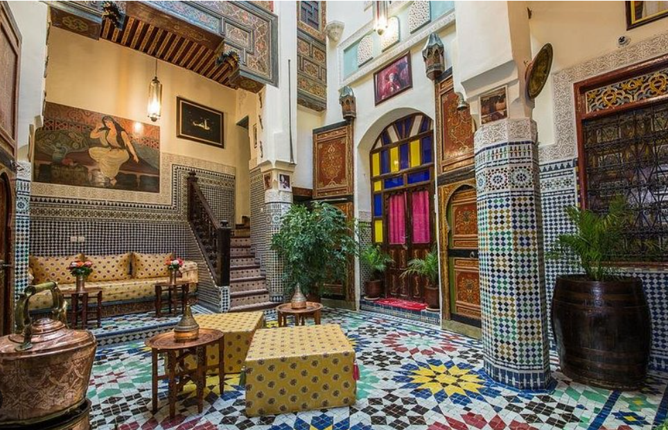 Cour intérieure traditionnelle d'un riad à Fès pas cher dans la médina avec zelliges et décoration marocaine.