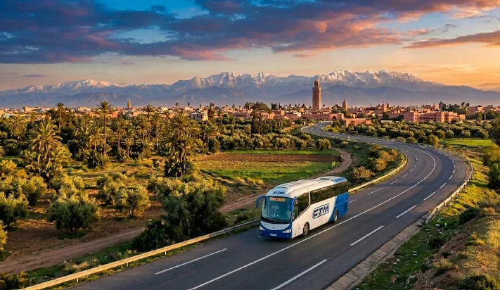 Blue and white CTM Casablanca Marrakech bus driving on the road with the Moroccan landscape in the background.