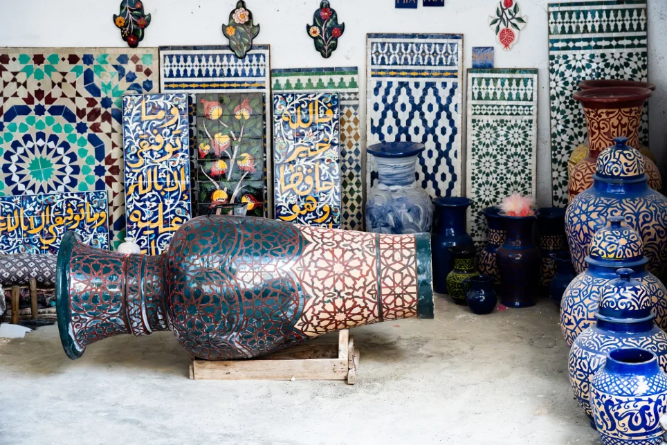 Artisanat marocain comparant céramique vs zellige avec poteries peintes à la main et mosaïques géométriques