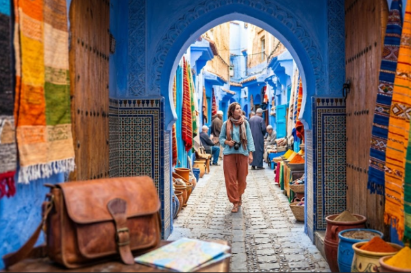 Une touriste explore en toute sécurité la médina bleue de Chefchaouen au Maroc, illustrant le guide de sécurité voyage au Maroc.