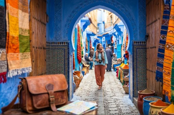 A tourist safely explores the blue medina of Chefchaouen in Morocco, illustrating the guide to Morocco travel safety.